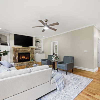 Spacious living area featuring a cozy fireplace, large windows, and modern finishes, ideal for gathering.