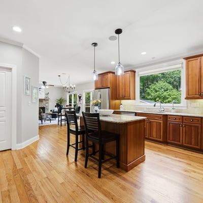 Modern kitchen with spacious island, abundant natural light, and rich wood cabinetry, perfect for entertaining.