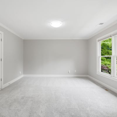 Spacious room with large windows offering natural light, perfect for customization and personal touches.