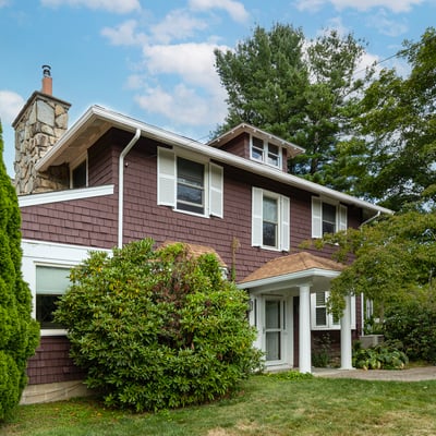 Spacious home featuring unique architectural details and ample greenery, perfect for outdoor gatherings and relaxation.