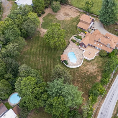 Sprawling property with two pools, vibrant greenery, and ample space for outdoor activities and relaxation.