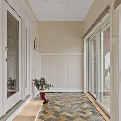 Bright entryway featuring unique herringbone floors, large windows, and ample natural light, ideal for welcoming guests.