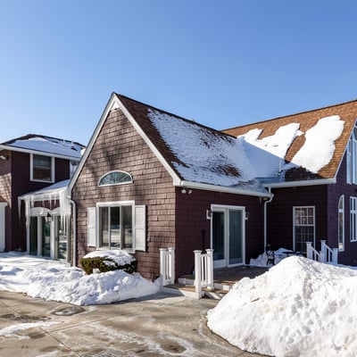 Spacious multi-level home featuring ample parking, surrounded by winter scenery, perfect for year-round living.