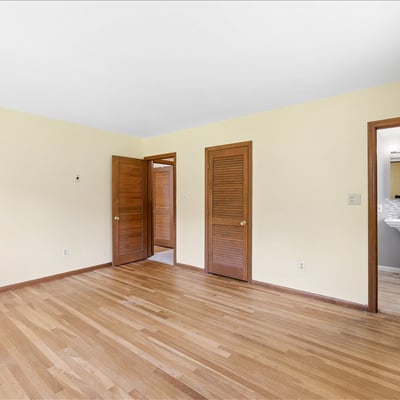 Bright, spacious room with warm wood accents, offering versatile layout and easy access to adjacent areas.