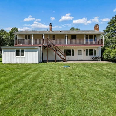Spacious two-story home with a vast backyard and multiple outdoor areas for relaxation and entertainment.