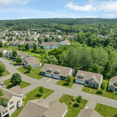 Spacious community with well-maintained homes, surrounded by lush greenery and convenient access to local amenities.