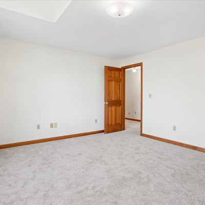 Spacious, versatile room with neutral tones, ample natural light, and convenient access to adjacent areas.