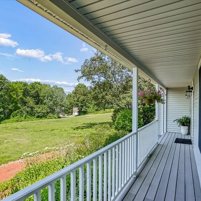 Enjoy expansive views from this spacious front porch, perfect for relaxing or entertaining amidst nature.