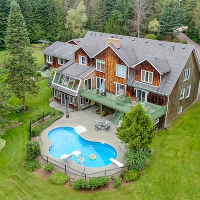 Expansive property featuring a private pool, lush greenery, and multiple outdoor spaces for relaxation and entertainment.