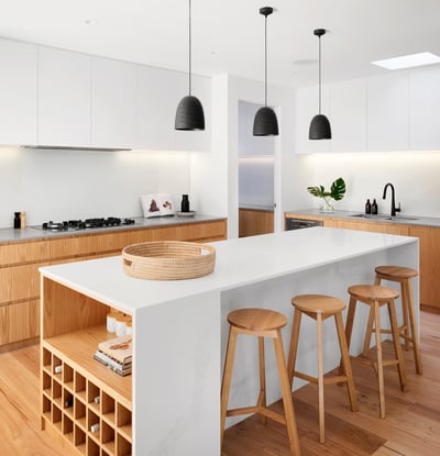 Modern kitchen featuring sleek countertops, stylish pendant lighting, and a spacious island with wood accents.