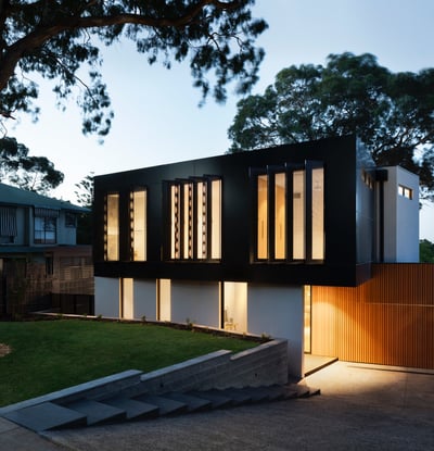 Contemporary home featuring striking architecture, large windows, and beautifully landscaped grounds in a serene setting.