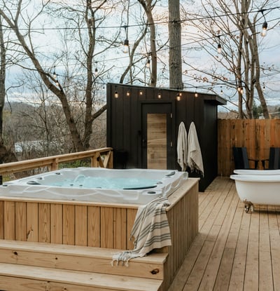 Discover a private outdoor oasis featuring a relaxing hot tub and a secluded sauna amid scenic woodlands.
