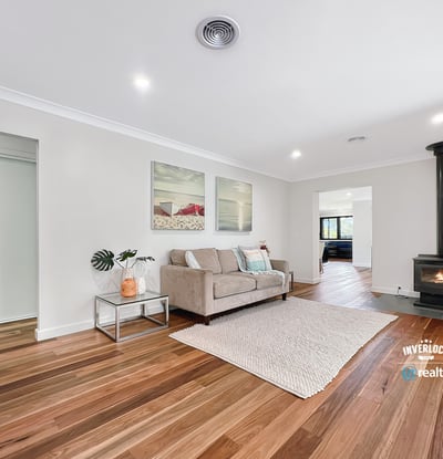 Spacious living area featuring hardwood floors and a cozy wood-burning stove, perfect for gatherings and relaxation.