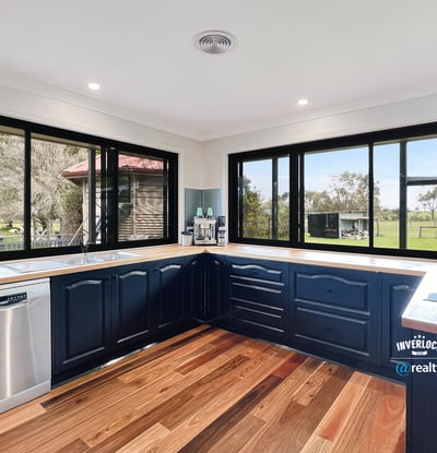 Modern kitchen with panoramic windows, featuring sleek cabinetry and scenic views of the surrounding landscape.