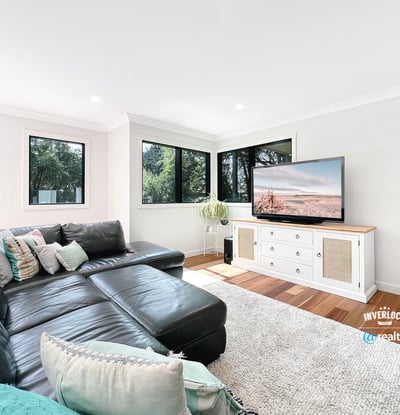 Spacious living area features large windows, modern furnishings, and ample natural light for a welcoming atmosphere.