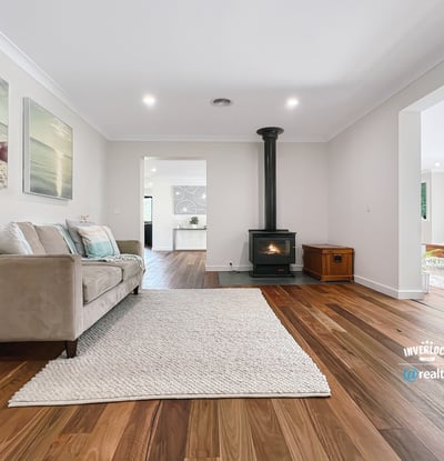 Spacious living area featuring natural light, modern decor, and a cozy fireplace, perfect for gatherings.