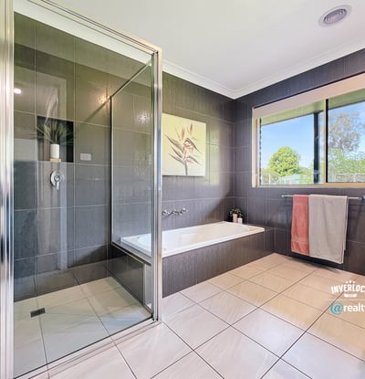 Modern bathroom featuring sleek tiles, a spacious shower, and large windows for natural light.