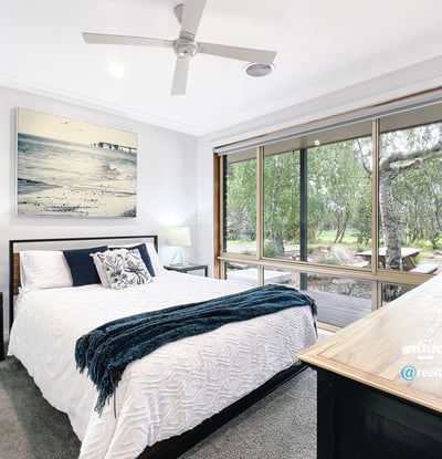 Bright bedroom with large windows offering scenic views and modern finishes for comfortable living.