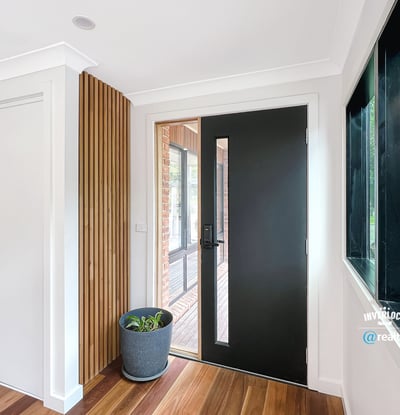 Contemporary entryway featuring a sleek front door and natural light enhancing the warm wooden floors.