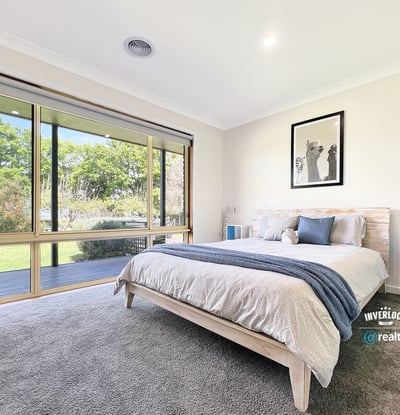 Bright and airy bedroom featuring large windows that invite natural light and offer picturesque garden views.