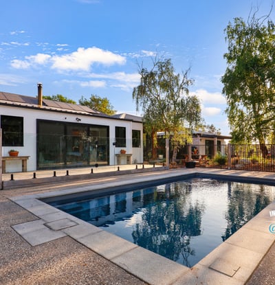 Discover a modern home featuring an inviting outdoor pool and spacious patio, perfect for entertaining.