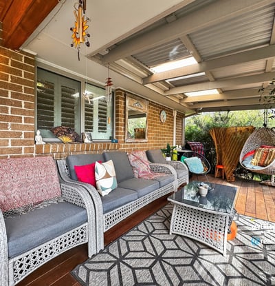 Discover a cozy outdoor retreat featuring comfortable seating and vibrant greenery, perfect for relaxing gatherings.