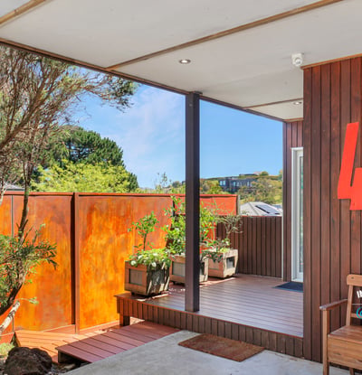 This inviting entry features unique architecture and a vibrant garden area, perfect for welcoming guests.