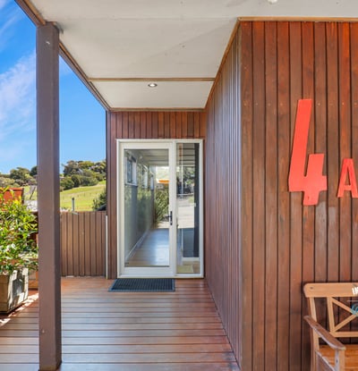 Modern entrance featuring natural wood accents, abundant greenery, and a bright, inviting atmosphere.