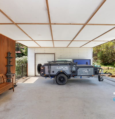 Spacious covered area perfect for storage or outdoor activities, featuring a convenient trailer setup.