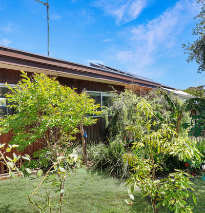 This inviting home features vibrant greenery and spacious outdoor areas, perfect for relaxation and entertainment.