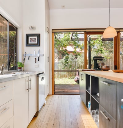 Modern kitchen with natural light, featuring sleek cabinetry and direct access to a spacious outdoor area.