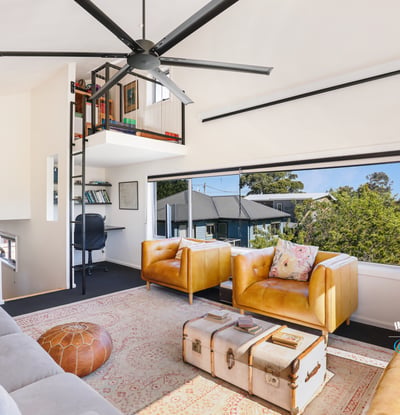 Bright and airy living space featuring unique shelving, cozy seating, and stunning outdoor views.