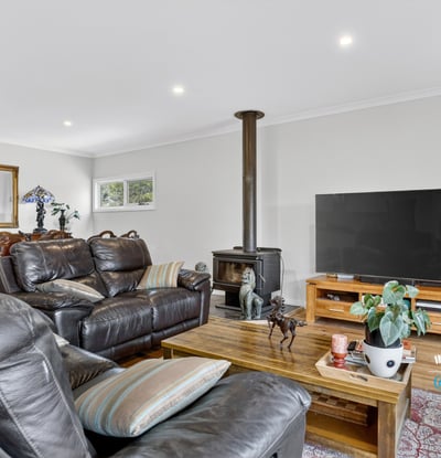 Spacious living area featuring a wood stove, ample seating, and an inviting atmosphere for gatherings.