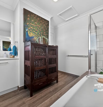 Contemporary bathroom featuring modern fixtures, natural light, and a unique wooden cabinet for added storage.