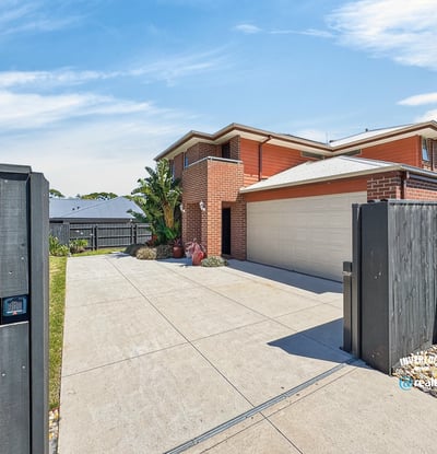 Spacious home with modern features, featuring a large driveway and well-maintained landscaping, perfect for family living.