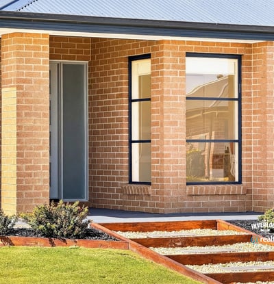 Contemporary brick home featuring unique architectural lines and a beautifully landscaped entryway.