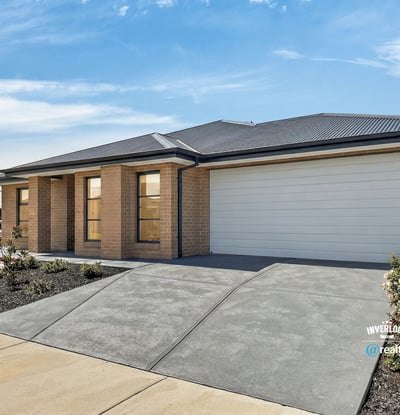 Modern home featuring a spacious driveway and large windows, perfect for natural light and convenience.