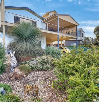 Modern home featuring a spacious design, lush landscaping, and panoramic views in a desirable neighborhood.