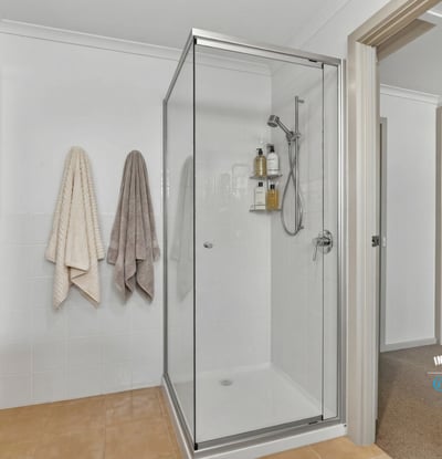 Bright and modern bathroom featuring a spacious walk-in shower and convenient storage options.