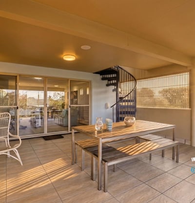 Spacious outdoor terrace featuring a spiral staircase, perfect for relaxation and entertaining with scenic views.