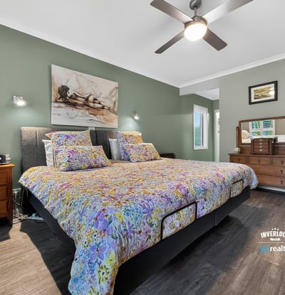Spacious bedroom featuring a large bed, modern fixtures, and a calming color palette for relaxation.