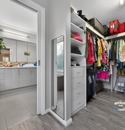 Spacious walk-in closet seamlessly connects to the laundry area, offering practical organization and efficient living.