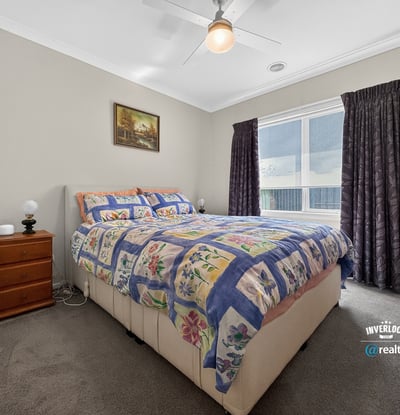 Bright bedroom featuring a spacious layout, large window for natural light, and cozy furnishings.