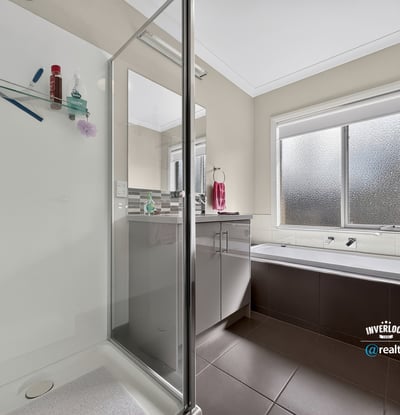 Bright and functional bathroom featuring a glass-enclosed shower and relaxing soaking tub for ultimate convenience.