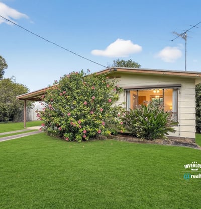 This inviting home features expansive gardens and a welcoming porch, perfect for outdoor relaxation and gatherings.