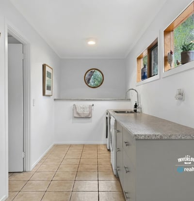 Bright and functional laundry space featuring natural light, ample counter space, and modern cabinetry.