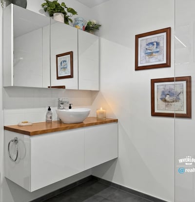 Modern bathroom featuring sleek cabinetry, artistic decor, and contemporary fixtures for a fresh ambiance.
