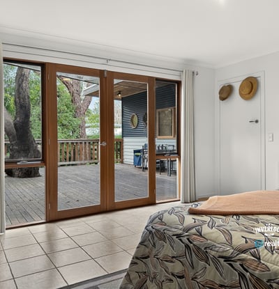 Bright and spacious bedroom with large sliding doors opening to a private outdoor deck area.