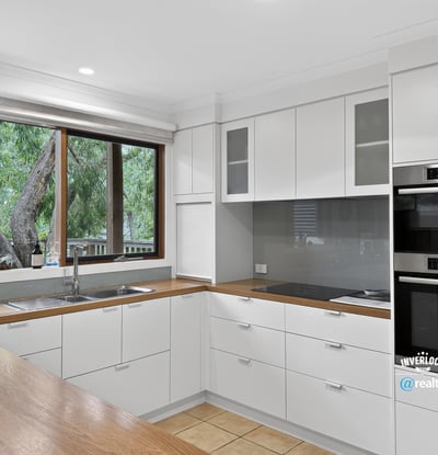 Modern kitchen featuring sleek cabinetry, quality appliances, and abundant natural light from large windows.