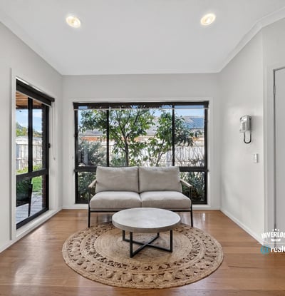Bright and inviting living space featuring large windows that offer a view of the lush garden.